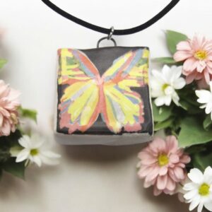 Abstract butterfly necklace with pink flowers around it